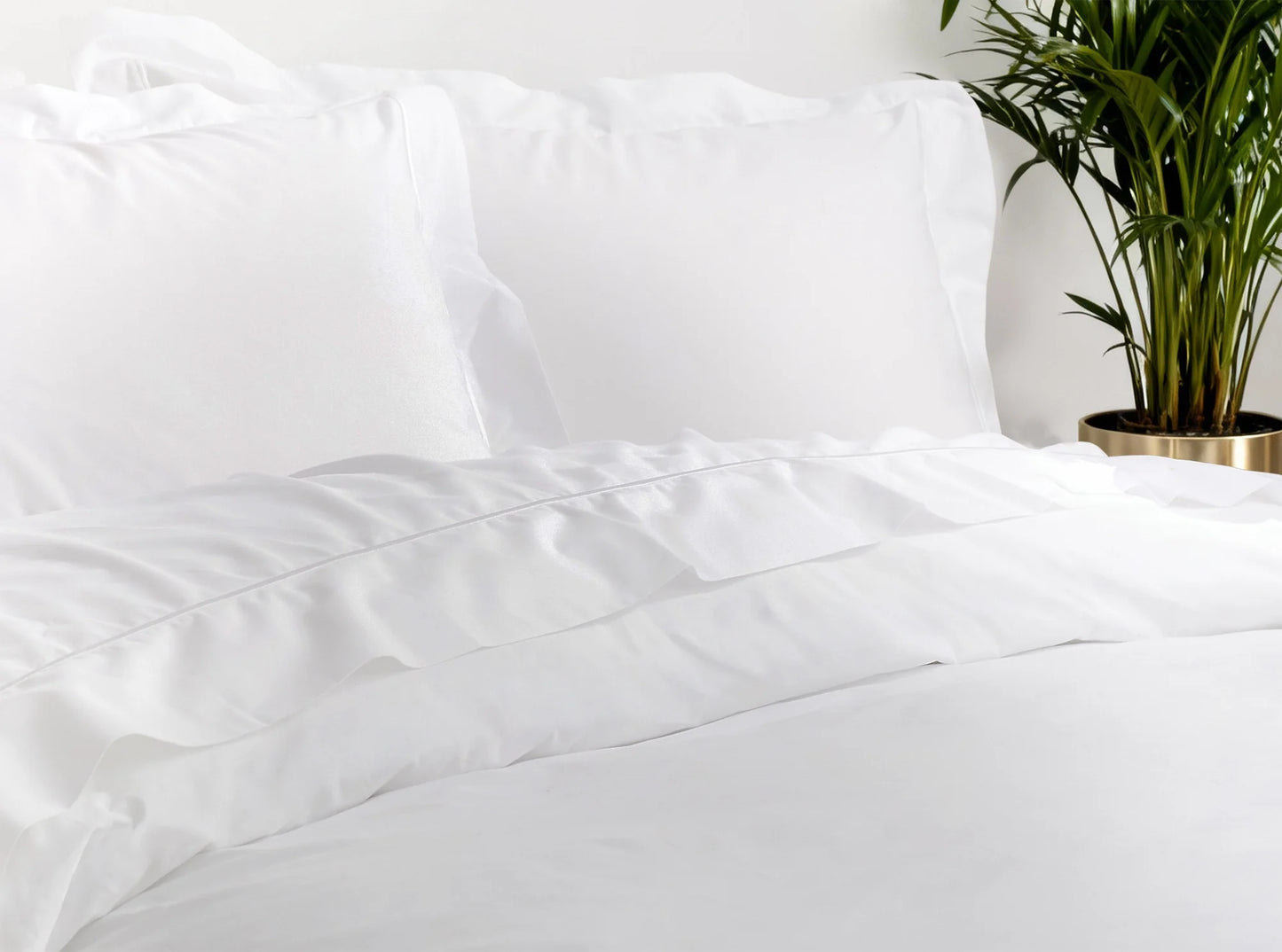 White organic percale bedding bundle styled on a bed in a modern bedroom with decorative accents-white-white
