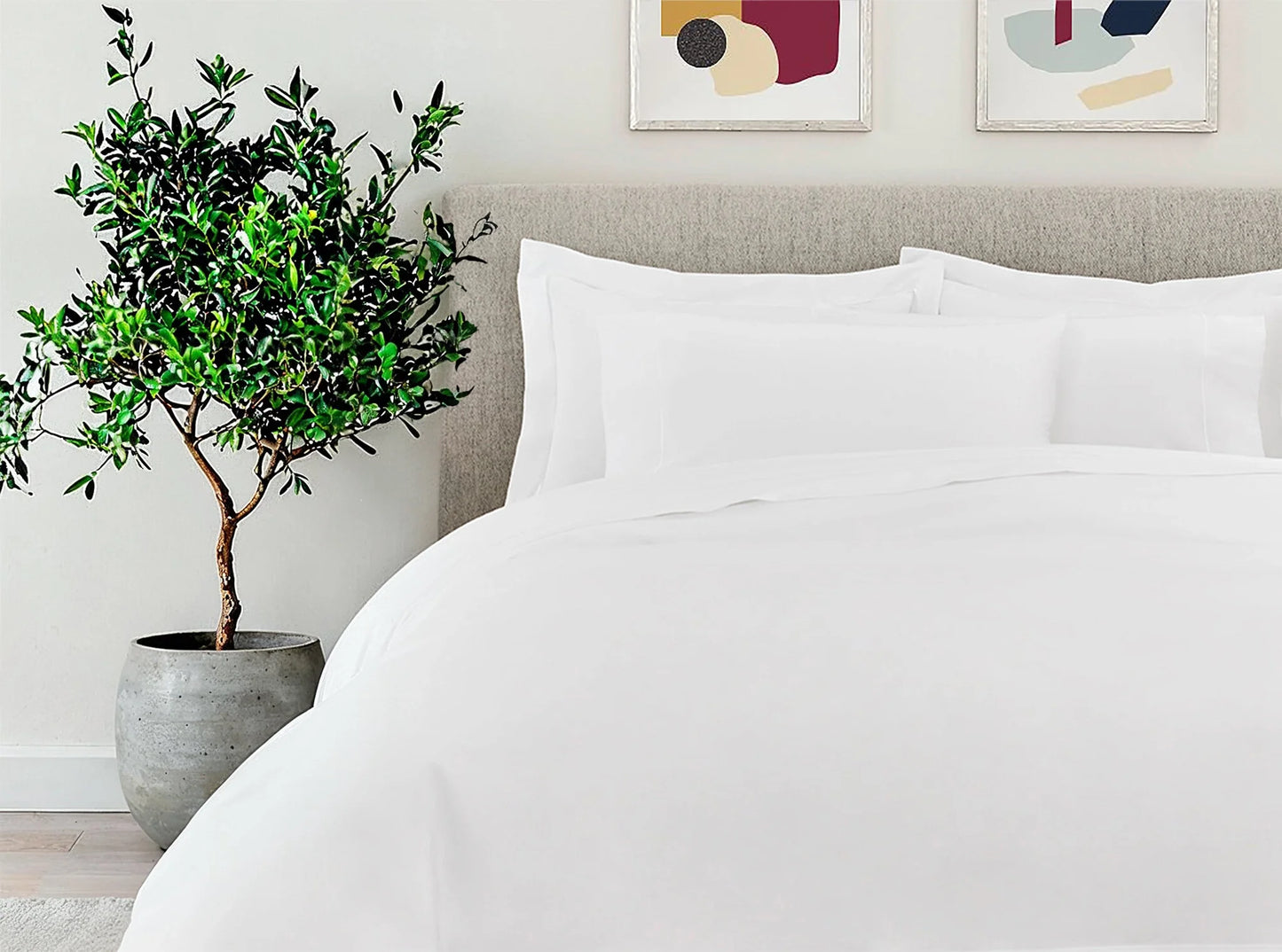 White organic cotton percale sheets with embroidered pillowcases on the bed in a modern minimalist bedroom