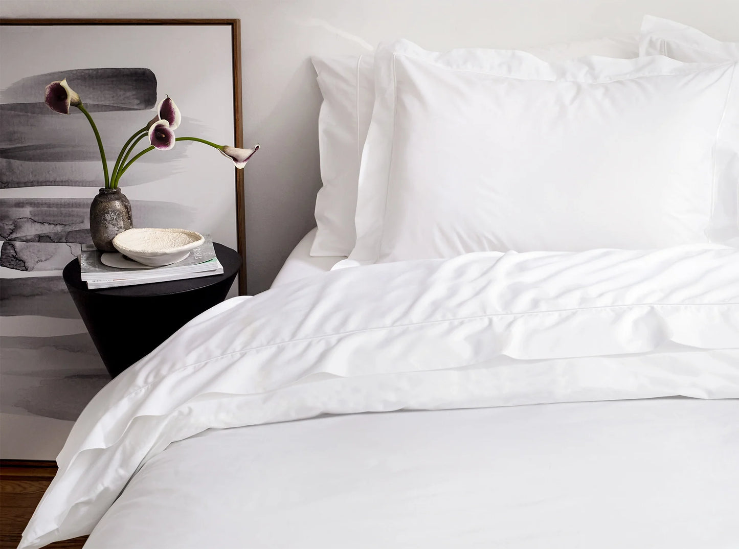 White organic cotton percale duvet cover with embroidered detail on the bed in a modern bedroom