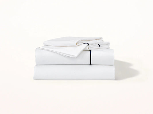 Organic cotton percale sheet set with navy blue embroidered detail on white - elegant contrast